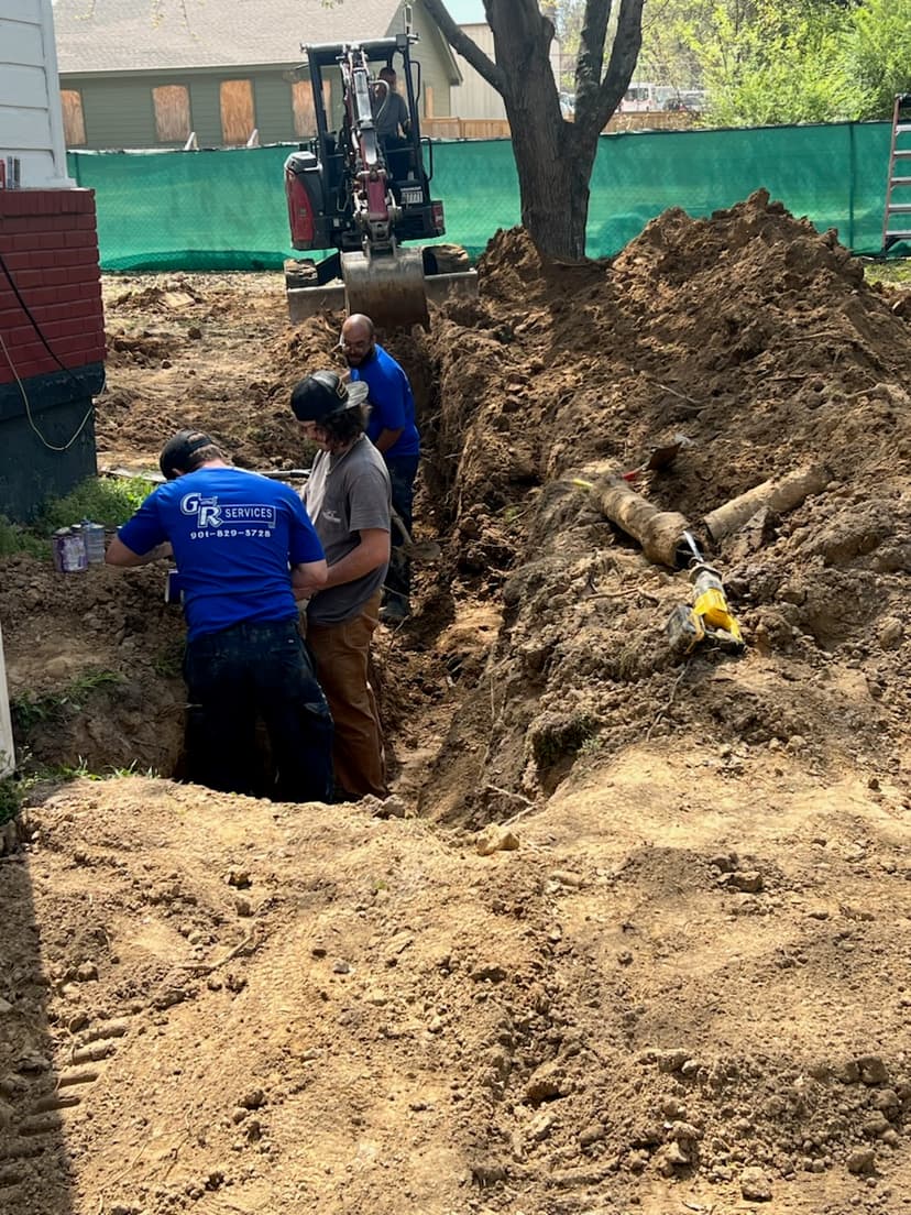 G & R Services crew working on underground pipe installation with excavator